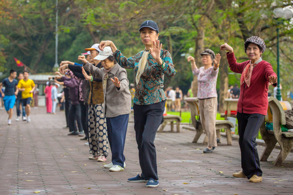 Hanoi, Vietnam - April 6, 2014: Group of Vietnamese seniors practice Tai Chi early in the morning on the bank of Hoan Kiem lake on April 6, 2014 in Hanoi.